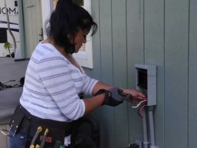 Licensed electrician wiring an exterior subpanel in Fulton